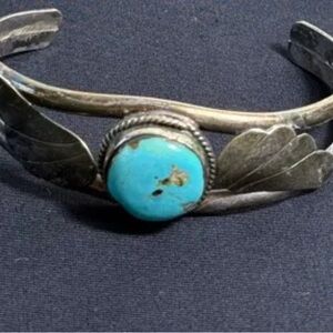 Vintage Navajo sterling silver cuff bracelet with turquoise and feather motifs